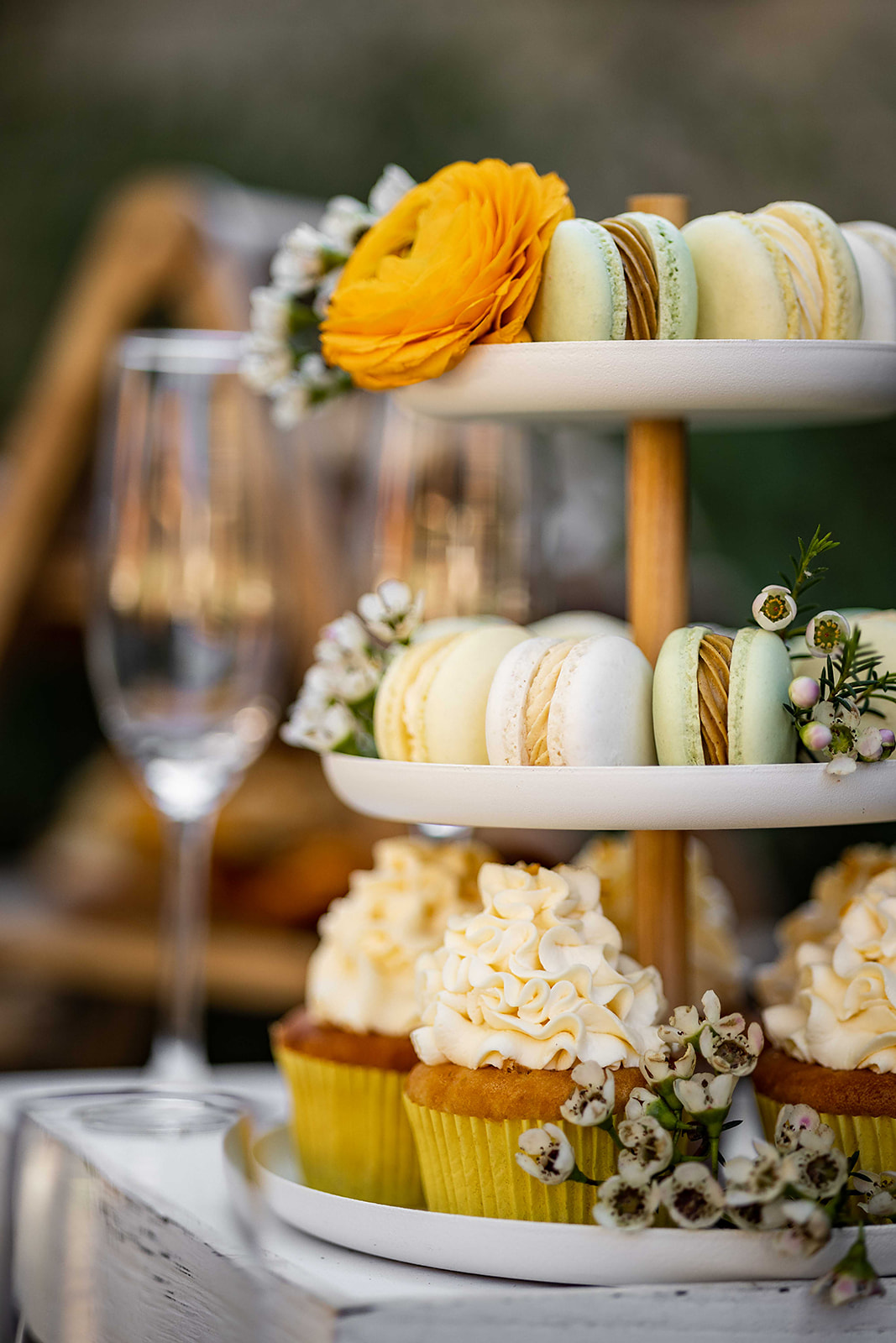 Macaron- und Cupcake-Etagere mit frischen Blumen